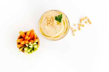 Bowl of hummus with carrot sticks and chickpeas, top view