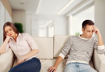 Unhappy sad couple sitting on a couch