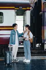 Tourist couples showing their love and happiness in a sweet way while waiting for their journey at the train station.