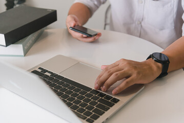 Man using touchscreen smartphone to stay connected, browse the internet, access information, and engage with social media.