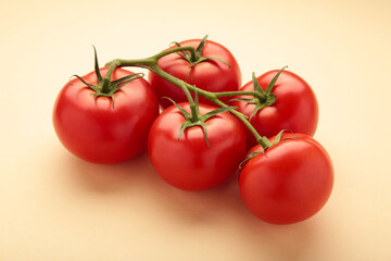 Flat lay composition with bunch of tomatoes on beige background. Space for text