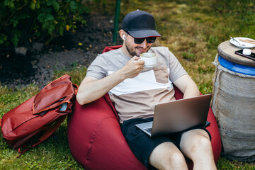 Casual adult men working with laptop outdoor