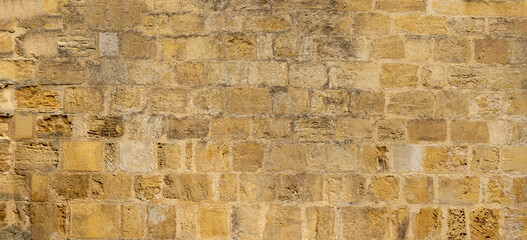 Light brown yellow dry stone wall texture, sandstone, medieval french wall, Pressac, France