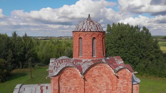 The old Orthodox Church of the Savior on Kovalev on the outskirts of Veliky Novgorod. The view from the drone on a sunny day.