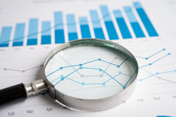 Obraz premium Magnifying glass on graph paper. Financial development, Banking Account, Statistics, Investment Analytic research data economy, Business concept.