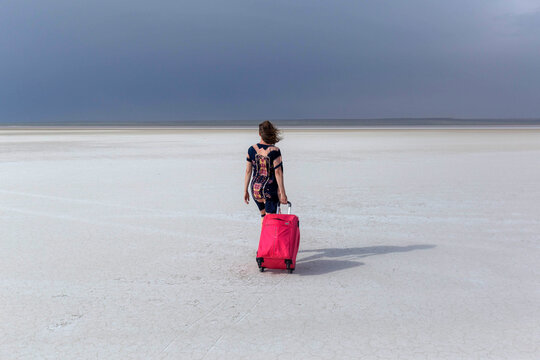 The girl with the red. with a suitcase on the Kazakh Salt Marsh