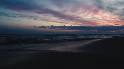 Fototapeta na wymiar Stunning sunset over sandy beach coastline