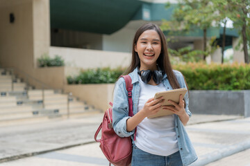 Beautiful student asian woman with backpack and books outdoor. Smile girl happy carrying a lot of book in college campus. Portrait female on international Asia University. Education, study, school