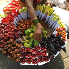 Different type of wild cherries in a basket for sale in front of Mumbai local train station.