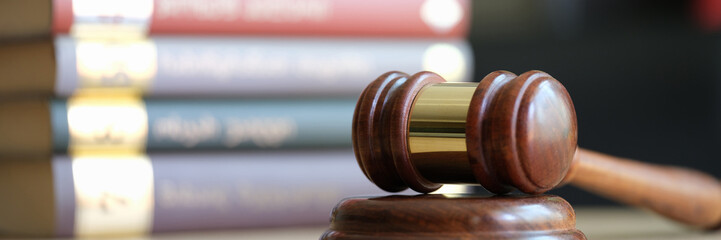 Judge gavel or hammer on sounding block and stack of law books