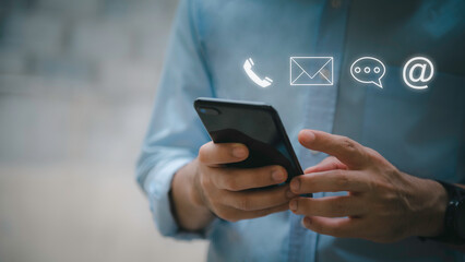 Businessman using Smart Phone with the email, call phone, address, Chat message icons.Customer support hotline Contact us people connection.