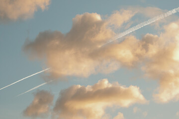 Naklejka na ściany i meble Jet line tracks through colorful clouds