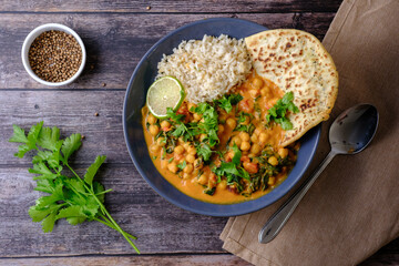 Vegan Chickpea curry on a dark background, top view, copy space. Healthy vegetarian food concept. Traditional Indian food concept.