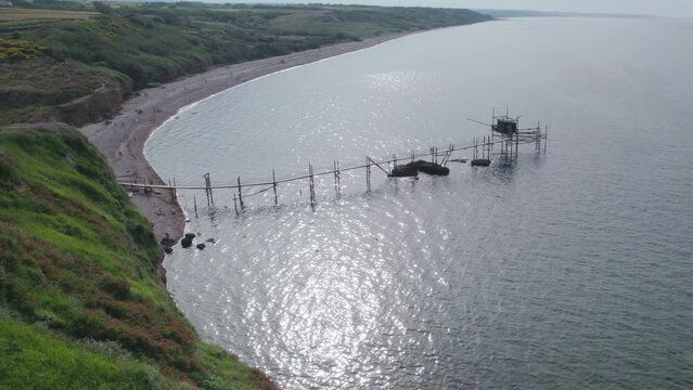 Impressive fishing platforms on stilts on the trabocchi coast of Abruzzo, Punta Aderci, Italy 4k drone