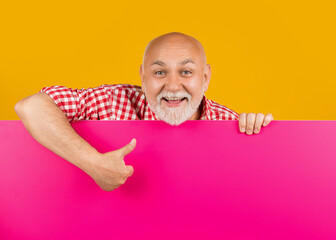 happy senior man with copy space on blank banner. promotion. thumb up