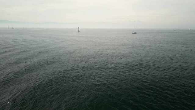 Sailing boat on foggy Swiss shore horizon at Bodensee. DE-Germany. Drone