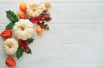 Halloween festive autumn background. Autumn decor from pumpkins, berries, maple leaves and chestnuts on old rustic white wooden backgrounds. Concept of Thanksgiving day Halloween. Top view copy space