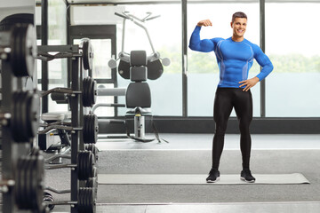 Fototapeta na wymiar Fit muscular man in leggings in a gym
