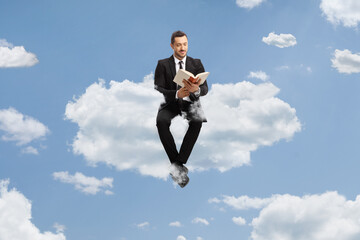 Fototapeta na wymiar Full length portrait of a professional man in a suit sitting on a cloud