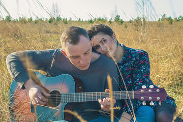 Man with a guitar and a girl next door. Rest of the lovers