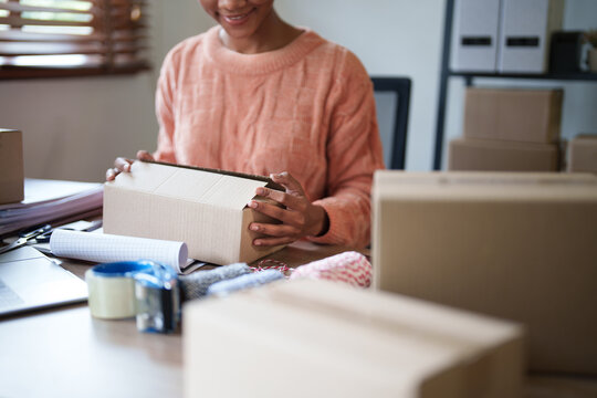 Startup young african american millennial packing products from online buyer..