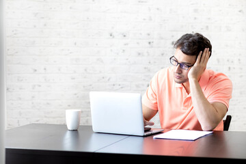 Stressed man working on laptop at home. Distance work concept