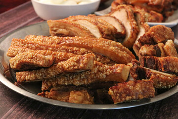 Close up view of a piece of Chinese roasted pork belly on wooden cutting board