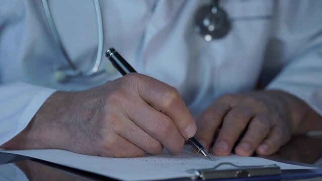 Family practice doctor in medical coat prescribes treatment for patient at appointment closeup. Doctor hands use piece of paper and clipboard