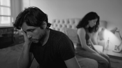 Desperate couple going through difficult times. Unhappy relationship breakdown. People suffering from a bad marriage in dramatic monochromatic black and white