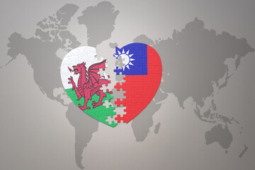 puzzle heart with the national flag of taiwan and wales on a world map background.Concept.