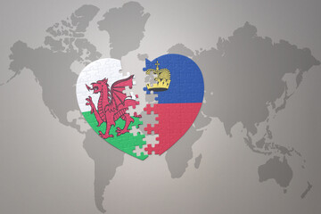 puzzle heart with the national flag of liechtenstein and wales on a world map background.Concept.
