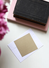 notebooks and an envelope with a blank golden message card on the table