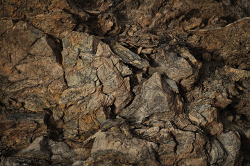 Dark brown red orange rock texture. Mountain. Close-up. Collapse, cracked, crumbled, crushed. 3d shape. Stone basalt surface background. Natural, outdoor. Backdrop.