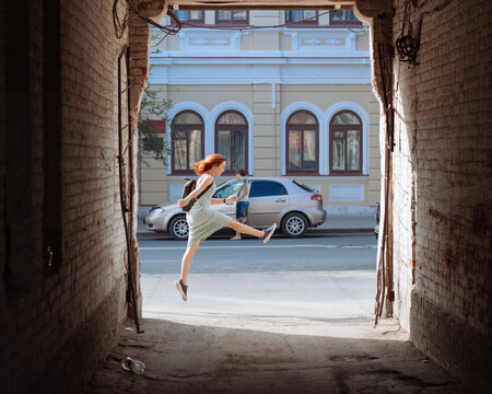 A girl in a jump on the background of an arch