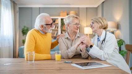 Fototapeta premium Home visit female doctor with senior man and woman couple at home talk