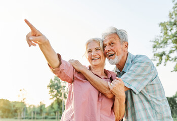 woman man outdoor senior couple happy retirement together elderly showing finger pointing hand  direction communication gesturing looking  active park