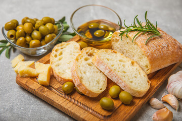 Italian ciabatta bread cut in slices with herbs, olives, pesto sauce, garlic and parmesan cheese on...