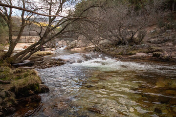 Impresionante paisaje de montañas rocosas en La Pedriza, con el río Manzanares serpenteando entre las formaciones de piedra. 