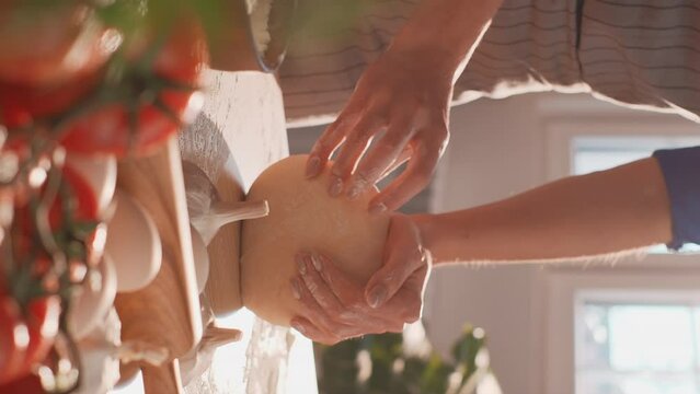 Closeup shot of kneading dough. Kneading dough by female hands on the table