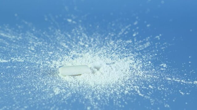Pile of Titanium dioxide, TiO2. Chewing gum and Chemical powder on blue surface. Food additive E171. Titanium dioxide often used in bubble gum as white pigment and thickener.