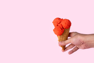 Red ice cream in a waffle cup on a pink background