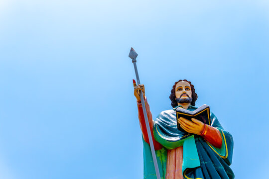 The majestic figure of Jesus Christ stands tall, captured in vagamon, embodying a sense of quiet strength and spiritual presence in the serene surroundings of blue sky.
