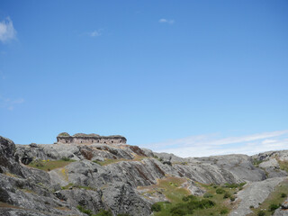 Marcahuasi chullpas, house made with stones on the top of a rocky mountain, archaeological remains in the mountains with a background of blue sky in South America