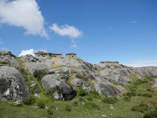 Marcahuasi chullpas, house made with stones on the top of a rocky mountain, archaeological remains in the mountains with a background of blue sky with clouds in South America
