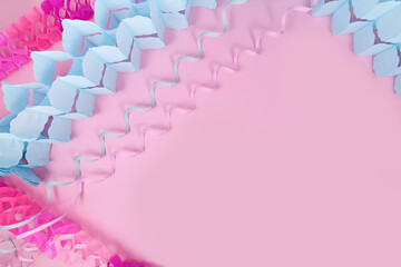 Fototapeta premium Party flatlay with pink and blue party blowout streamers and garlands on pink background with copy space