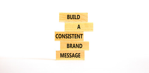 Consistent brand message symbol. Concept words build a consistent brand message on wooden blocks. Beautiful white table white background. Business consistent brand message concept. Copy space.