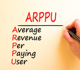 ARPPU average revenue per paying user symbol. Concept words ARPPU average revenue per paying user on white paper. Beautiful brown background. Business ARPPU average revenue per paying user concept.