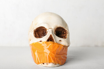 Taped human skull on white background. Censorship concept