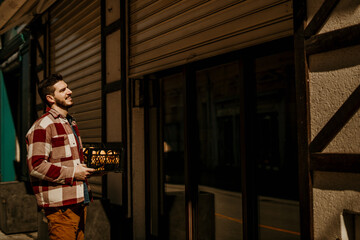 Obraz premium The Bar owner standing in front of his venue and opening the door.