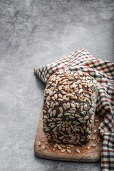 Homemade dark rye bread with sunflower seeds on gray background